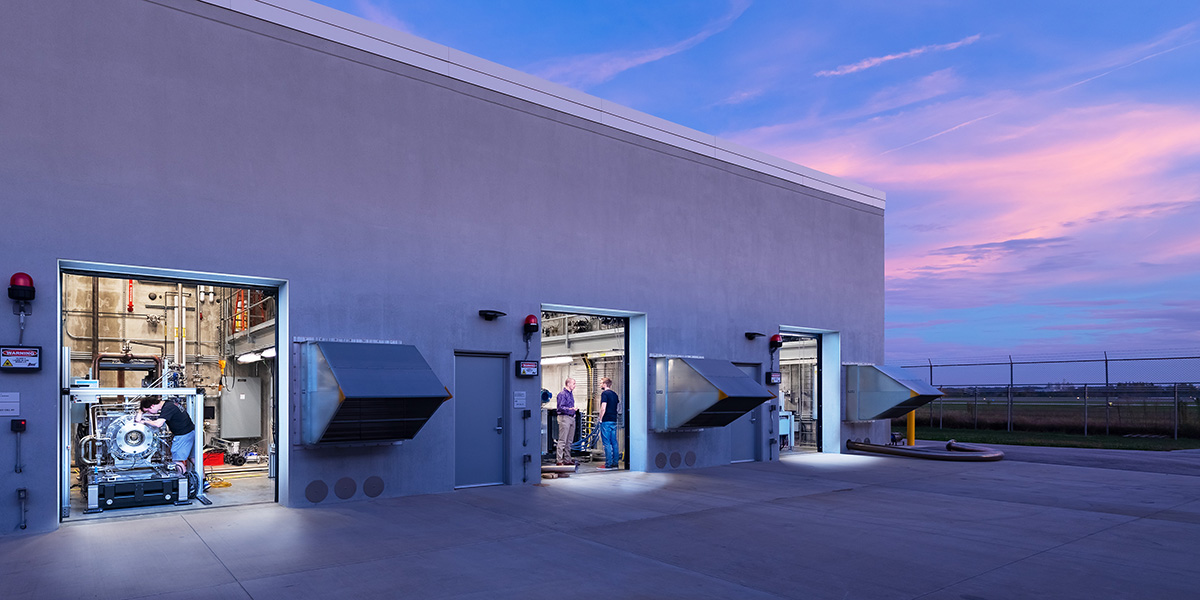 People working inside Zucrow Labs propulsion test cells at dusk