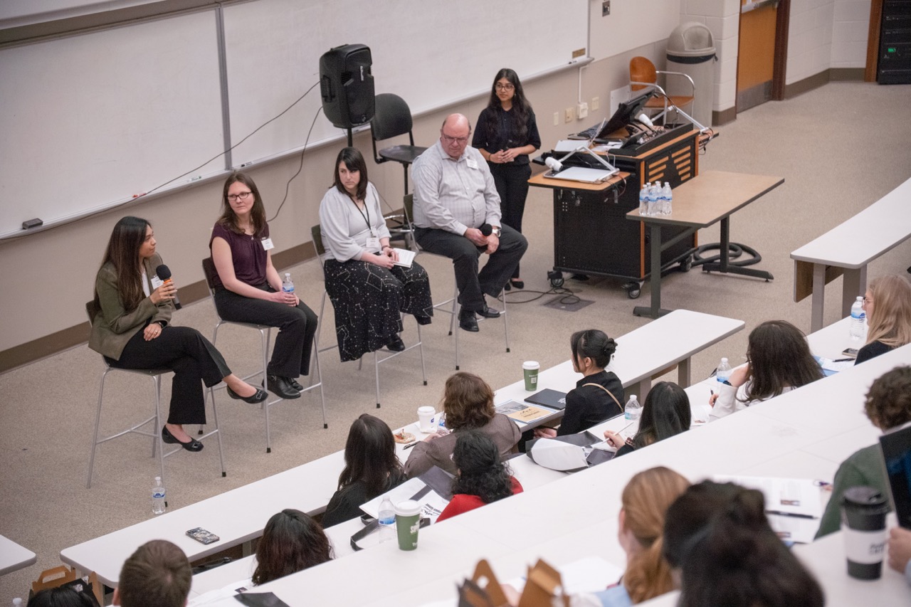four panelists speaking in front of a student audience