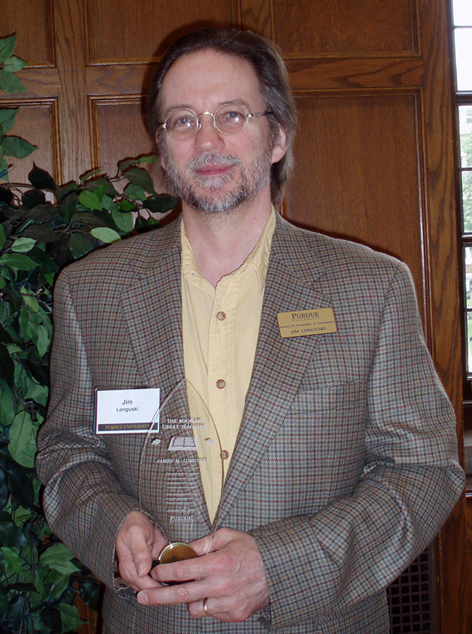 Jim Longuski holding his Book of Great Teachers award