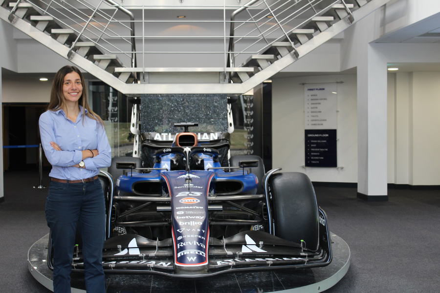 Claire Diffey posing with a Williams Racing car.