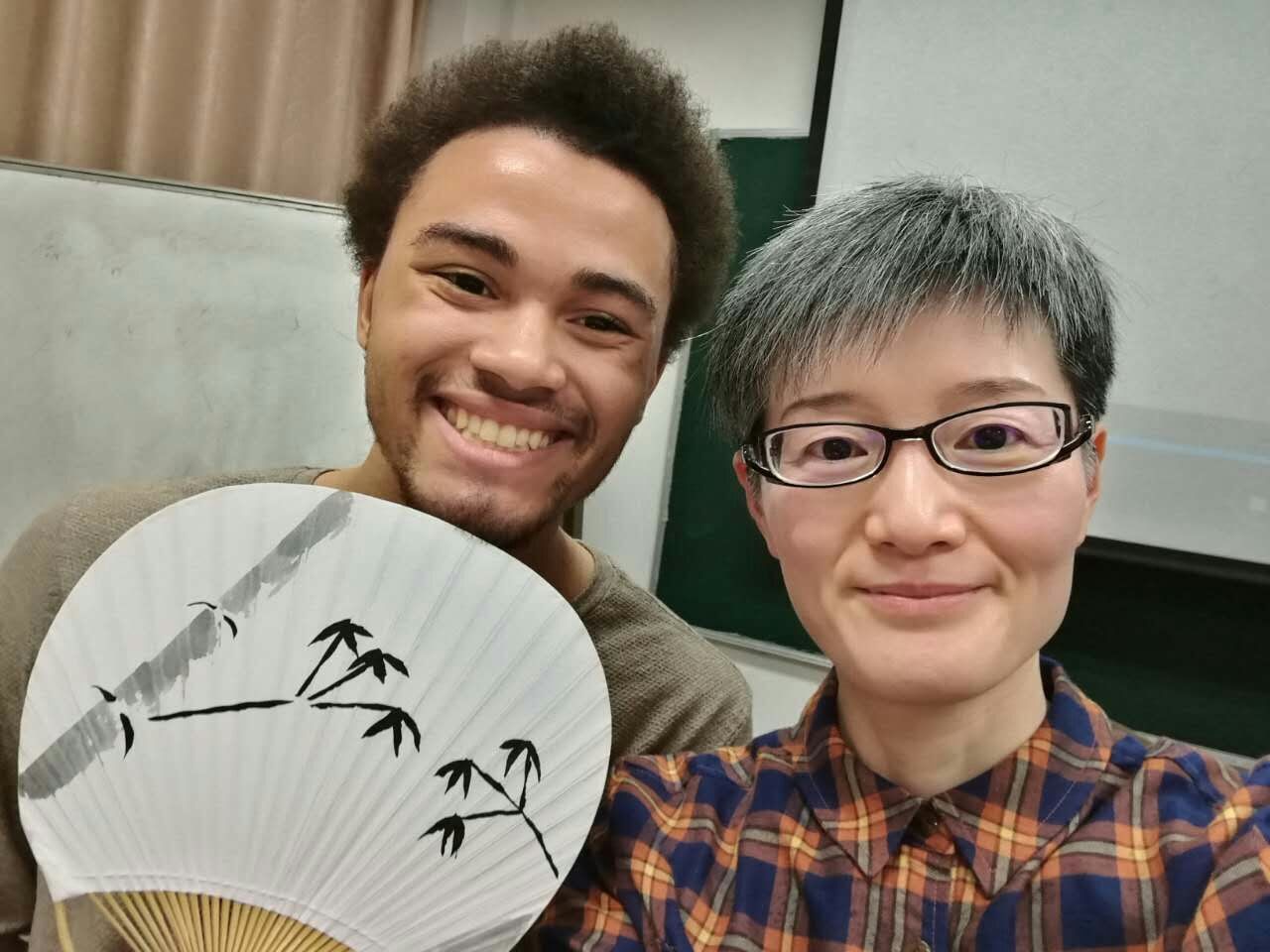 During a culture class field trip, SJTU program participant Jerome Alexander Marshall (left) learned how to paint traditional bamboo trees on fans.