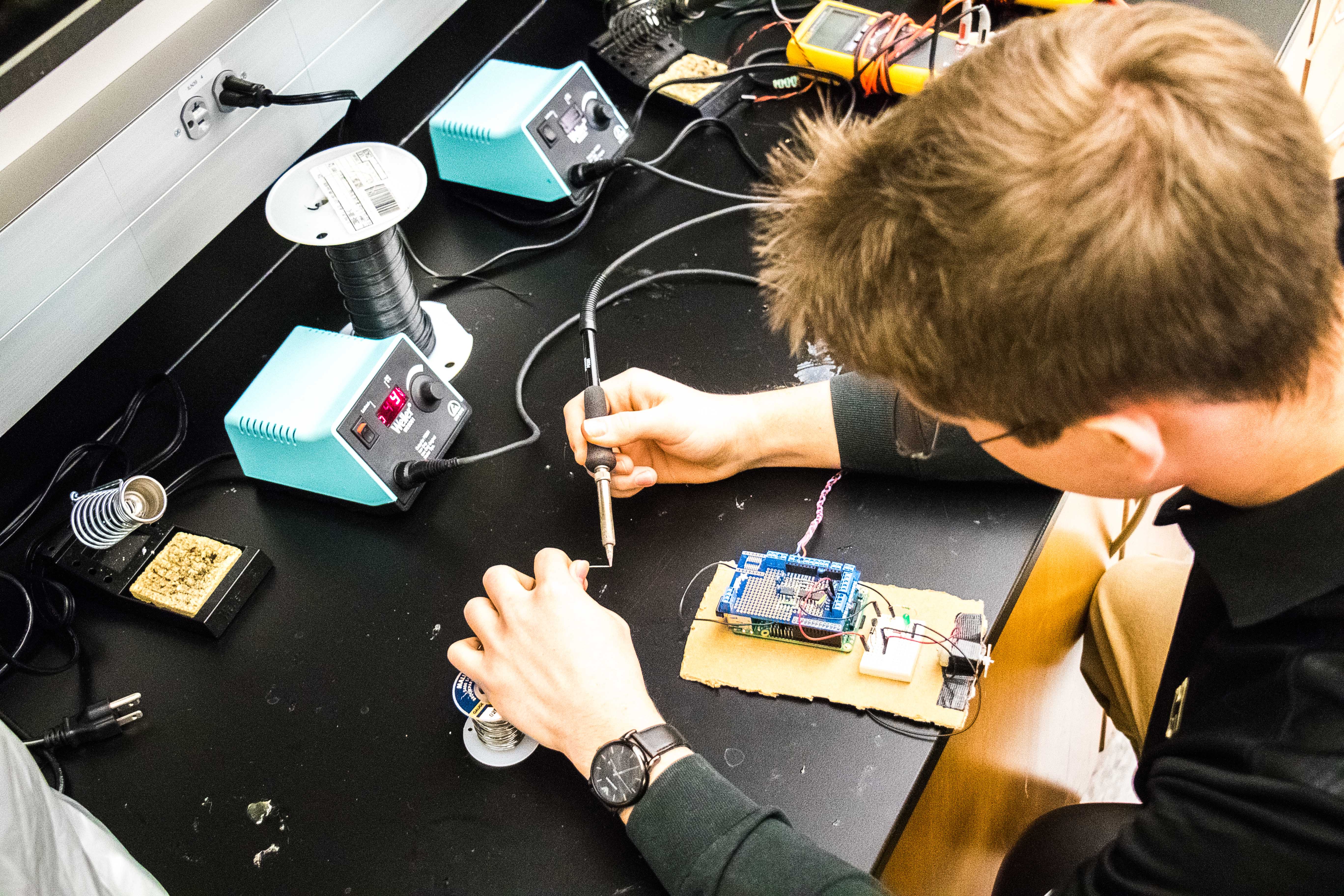 student soldering in the lab