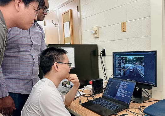 Graduate students Zengxiang Lei, Eunhan Ka and Omar Hamim test cybersecurity algorithms in the Urban Mobility Networks and Intelligence Lab.