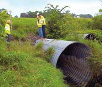 Student Xiao Zhang (white hard hat) with fellow researchers inspecting culverts near Peru, Indiana. (Photo: Mark Bowman)