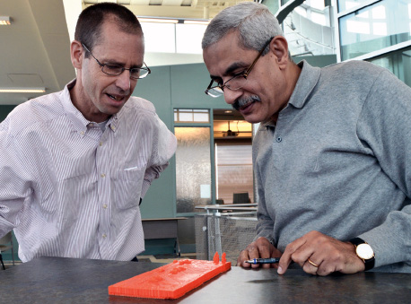 Civil engineering professors Darcy Bullock (left) and Ayman Habib review their latest 3-D printed traffi c site. The professors used UAV image data to print a three-dimensional, physical copy.