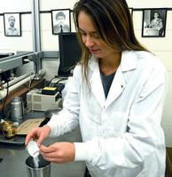 Lyles School undergraduate student Hailie Swanson pours the powder form of laponite in preparation to mix it.