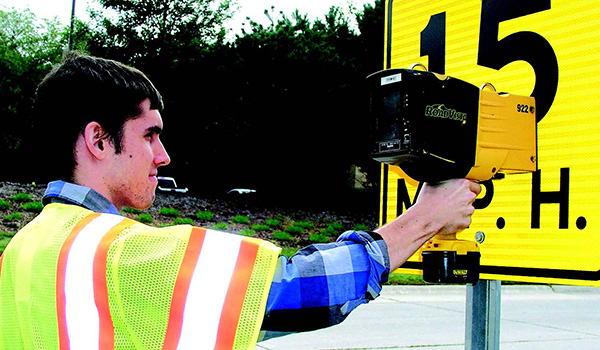 An LTAP undergraduate student measures the retroreflectivity of a street sign in West Lafayette. Retroreflective materials redirect the light from headlights back toward the vehicle.