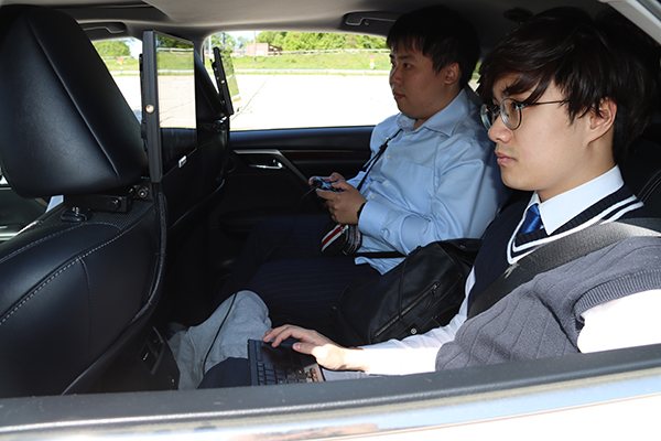 PhD students Yunsheng Ma (left) and Juanwu David Lu test automated driving features on their automated vehicle platform.