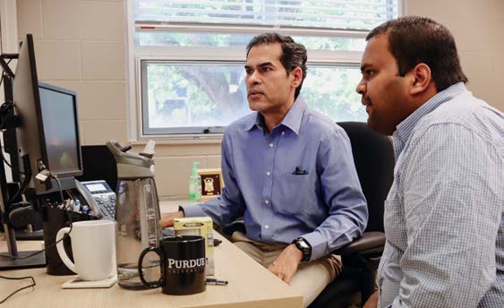 Professor Venkatesh Merwade (left) and PhD student Jibin Joseph review streamflow data.