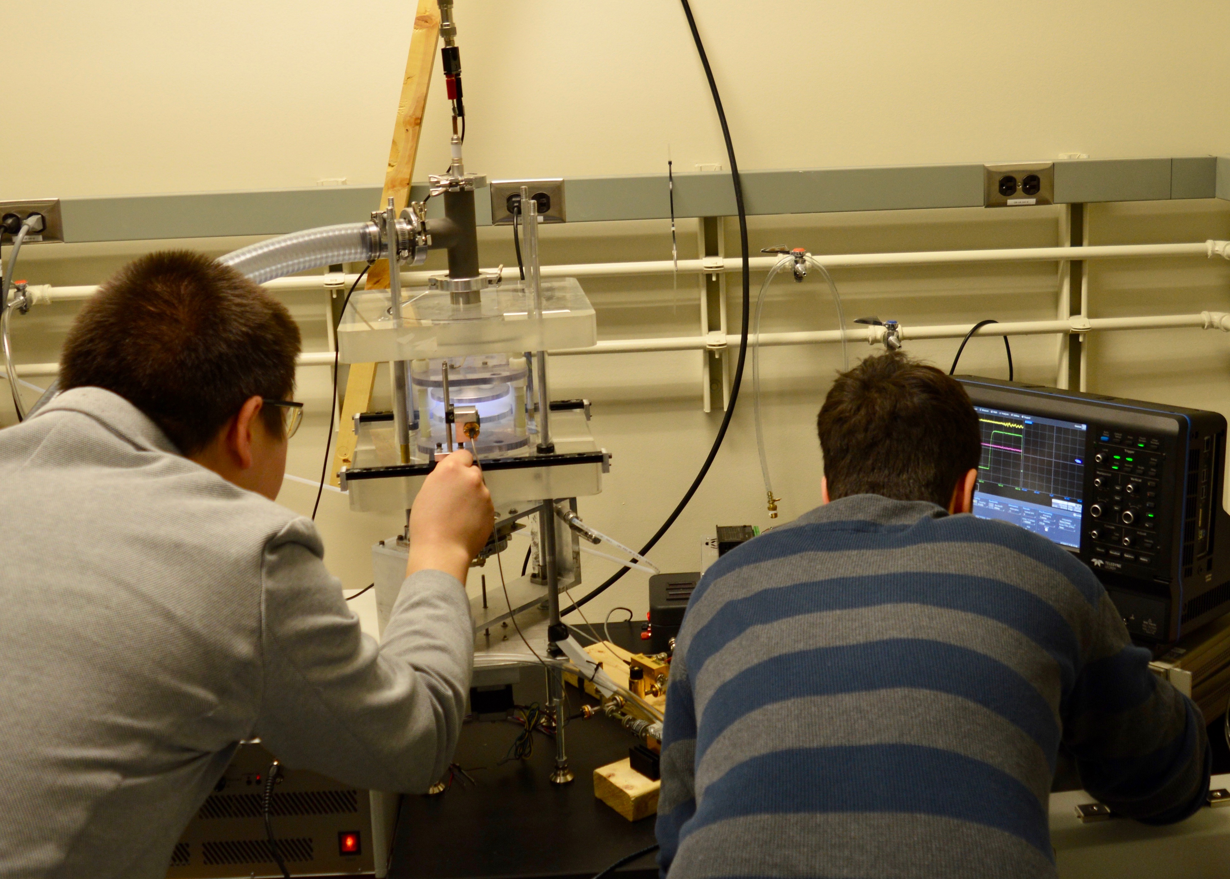 Dr. Andrey Khomenko (left) and Ph.D. student Vlad Podolsky (right) adjust the experimental apparatus.