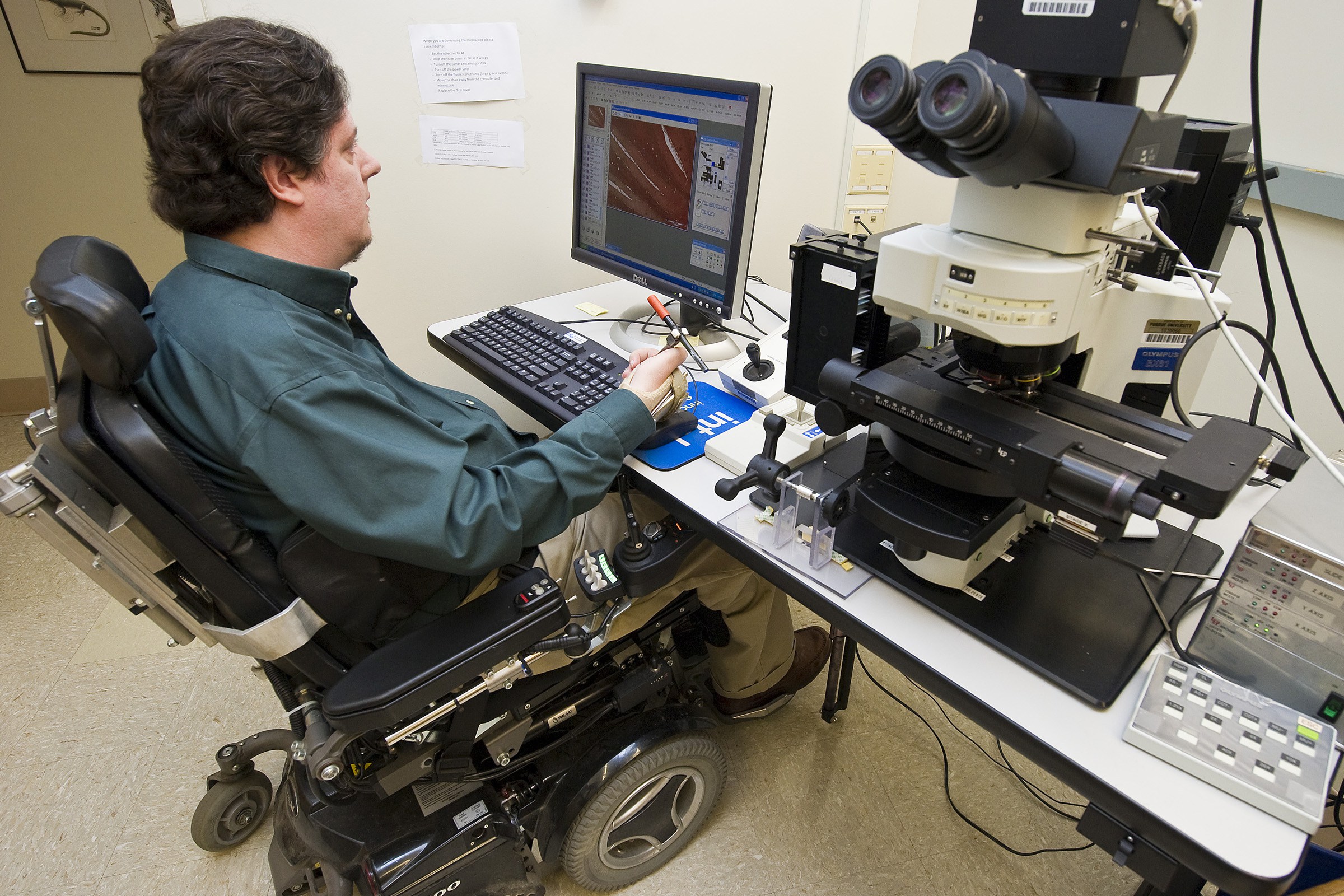 Photo of wheelchair user using an accessible light microscope