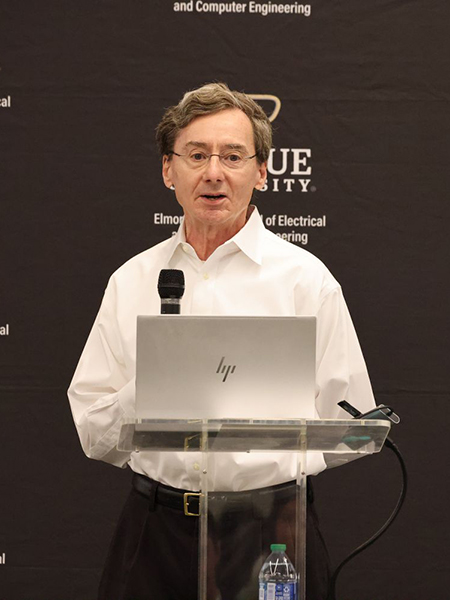 Professor David Janes stands at the podium during. Behind him is a Purdue ECE branded backdrop.
