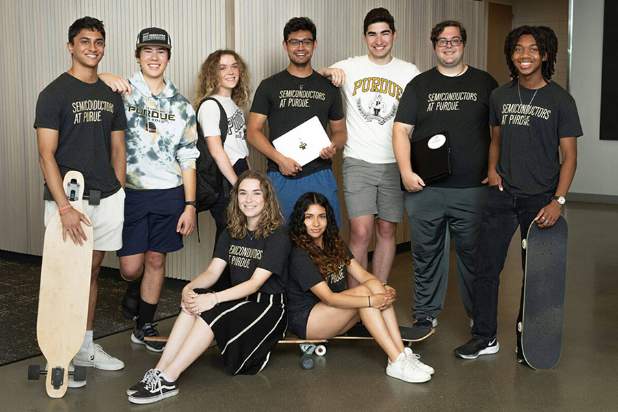 Group photo of students in the STARS program. Seven students are standing with the outside two students holding skateboards and two students are sitting on skateboards in the foreground. All are wearing Purdue branded shirts.