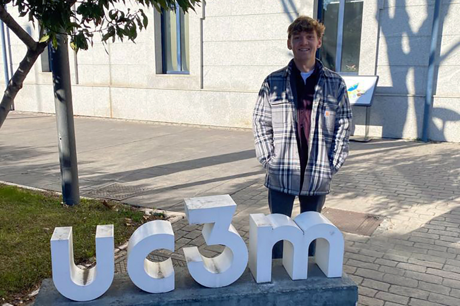 Aidan Anastario poses for a photo by a UC3M sign.