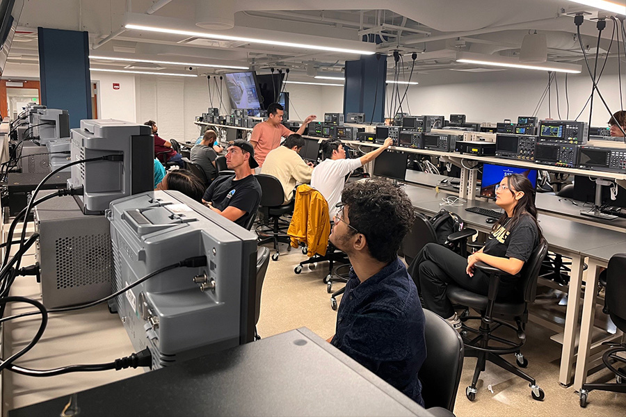 A diverse group of individuals at lab benches, concentrating on their work in a laboratory setting.