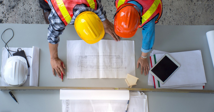 Engineers working over drafting table