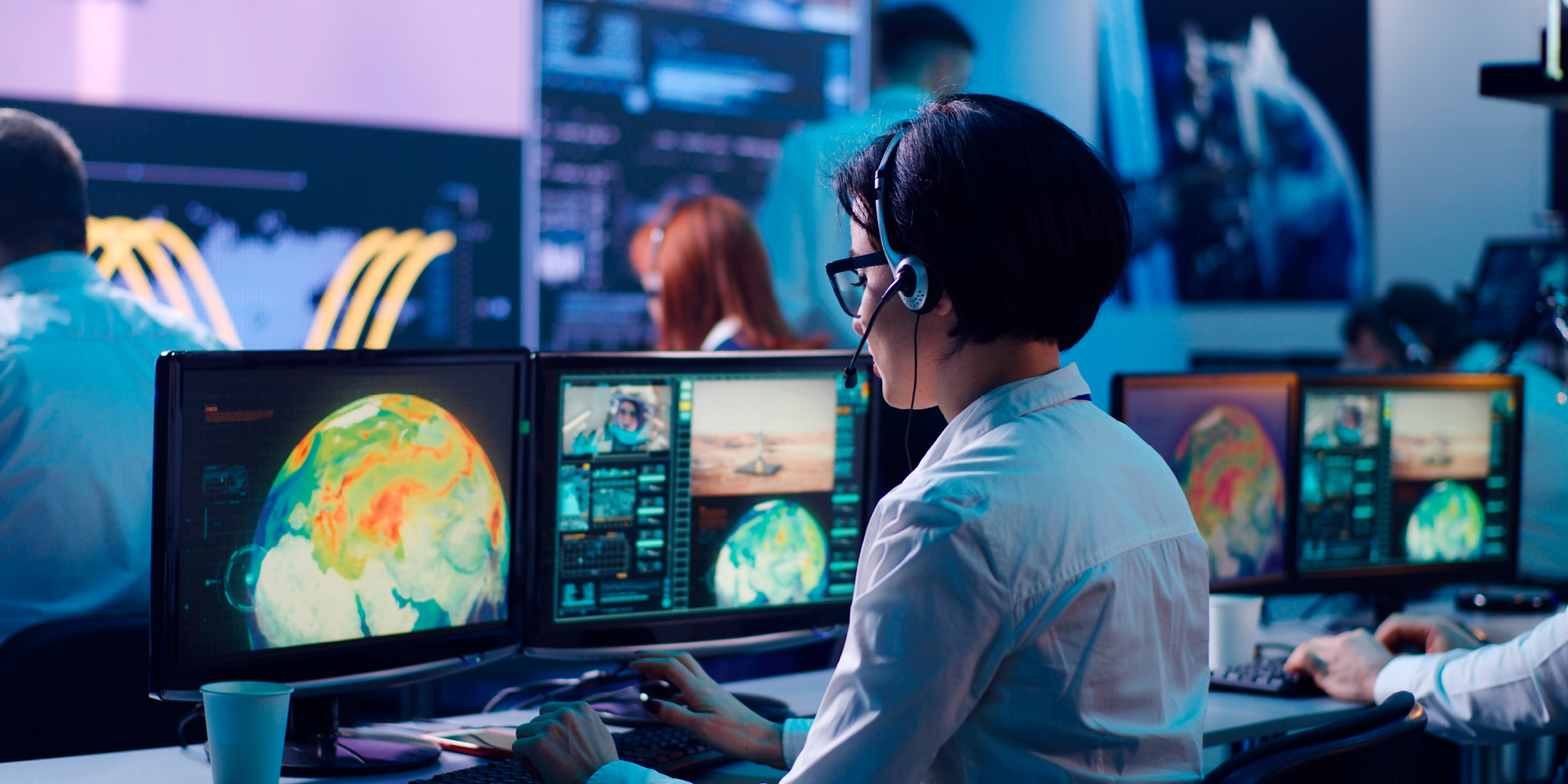 Woman sitting in front of a computer with a headset on