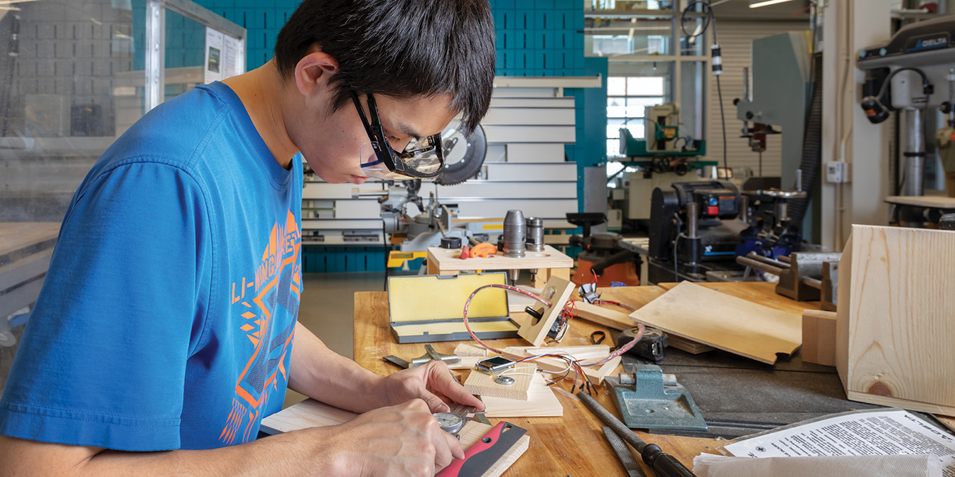 Man with goggles working on wood