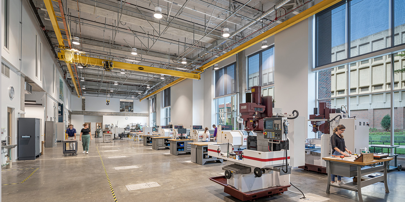 A room with a large machine and individuals working on it