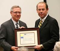 John Sutherland (right) receiving the award from 2011 SAE International President Richard E. Kleine