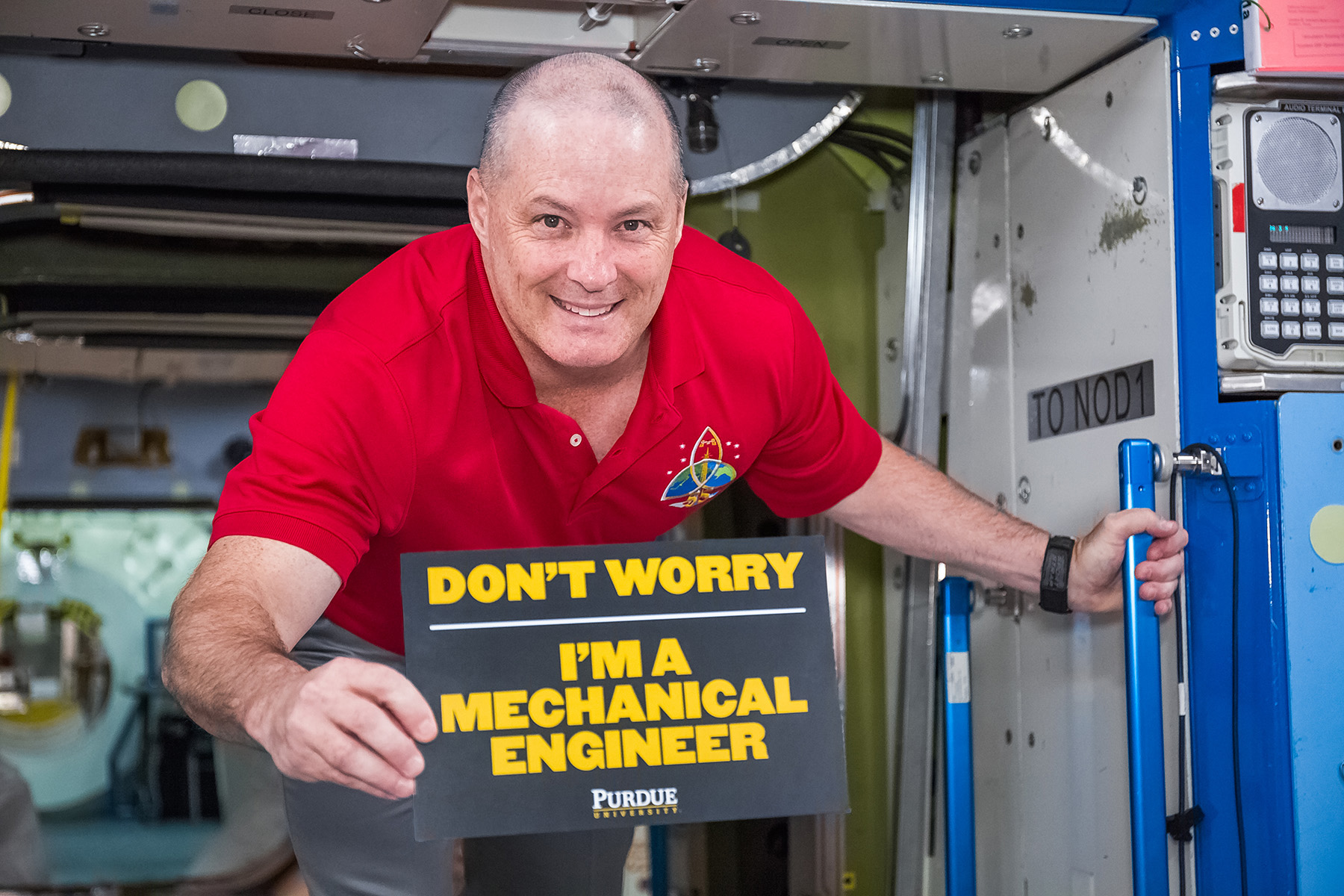 Scott Tingle holding up a sign that says - Don't worry, I'm a Mechanical Engineer - Purdue University
