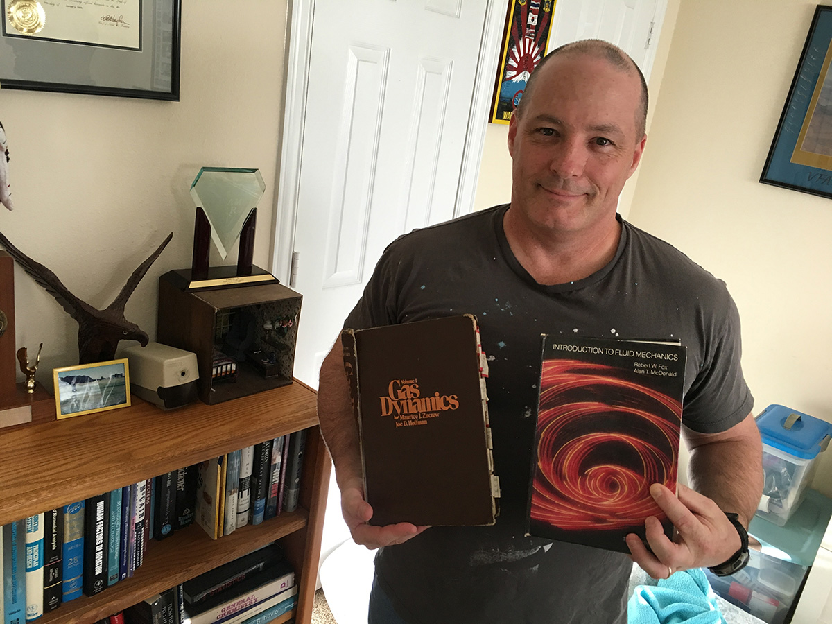 Scott Tingle shows off his 1987 Purdue textbooks: <em>Gas Dynamics</em>, written by Maurice Zucrow and Joe Hoffman, and <em>Introduction to Fluid Mechanics</em>, written by Robert Fox and Alan McDonald -- all former Purdue Mechanical Engineering professors.