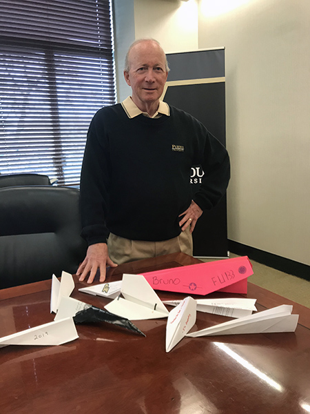 Photo of Mitch Daniels with collection of paper airplanes