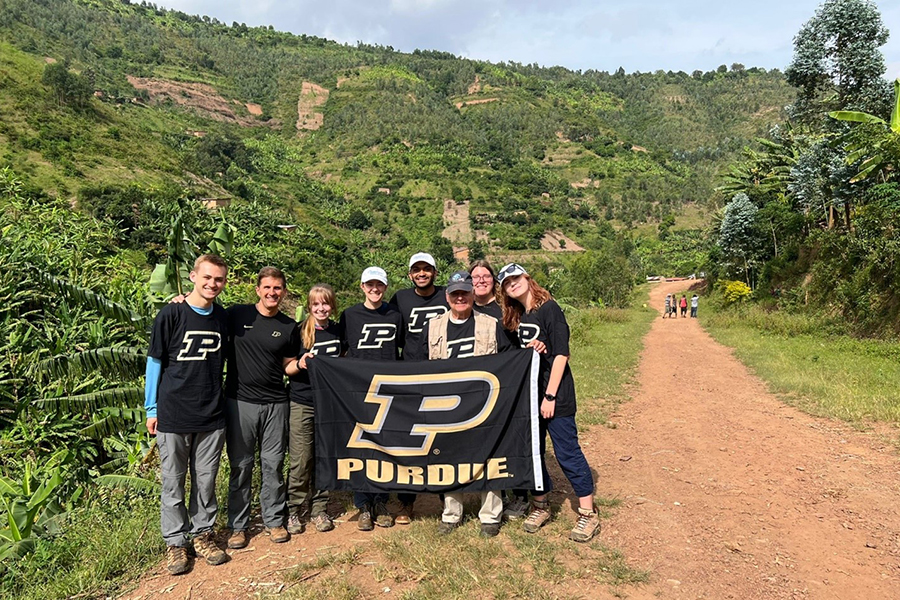 Group of Purdue students and advisors holding Purdue flag