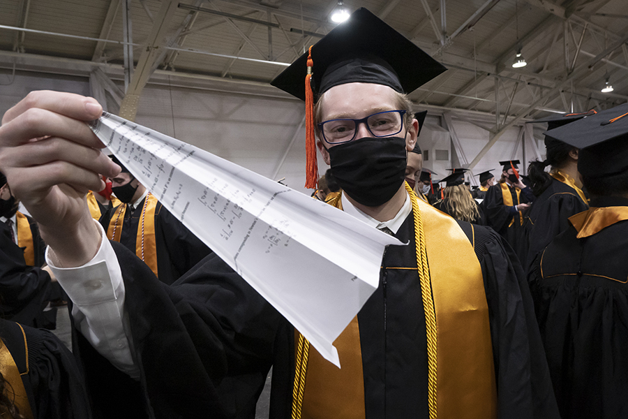 A student shows off his paper airplane