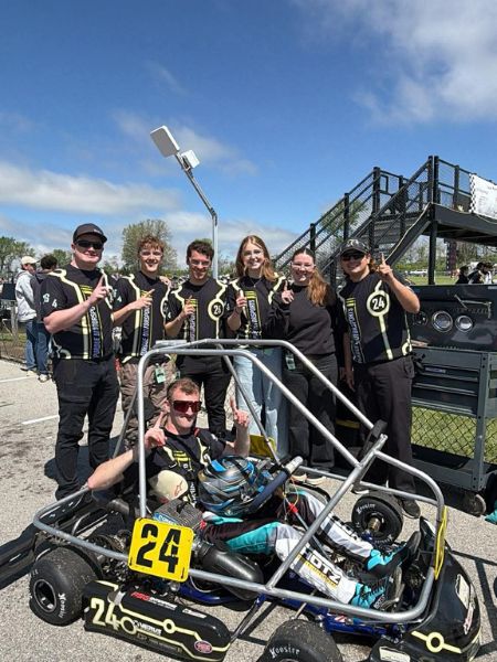 Alec Staley and Kart 24 teammates celebrate with their go-kart at the Purdue Grand Prix track.