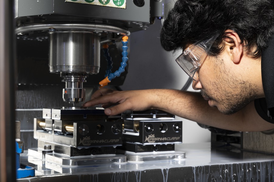 Anirudh Pal checks a CNC mill setup while machining a titanium Neil Armstrong Space Prize medallion.