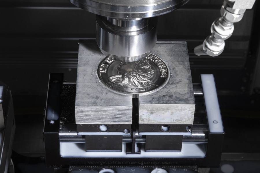 A titanium Neil Armstrong Space Prize medallion takes shape in a CNC mill at Purdue's Bechtel center.