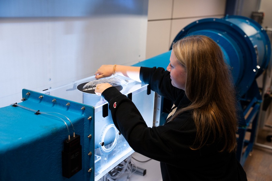 Olivia DeScipio sets up an experiment in the clear test section of a wind tunnel in a Purdue aerospace lab.