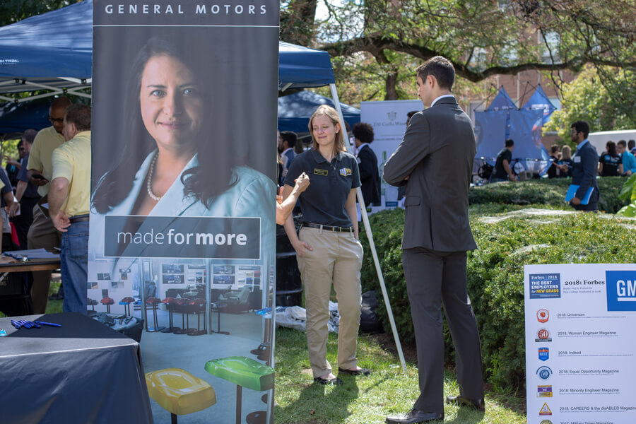 A student talks with a General Motors representative.