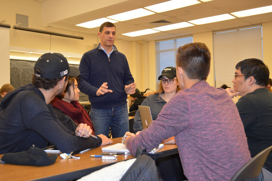 Civil Engineering Associate Professor Joseph Sinfield offers suggestions to the student group consisting of (from left) Santiago Balzaretti, Vanessa Bahk, Eleanor Ericson, Ford Fisher and Yu-Chung Lin. The group has been tasked with the issue of reducing traffic in large cities.