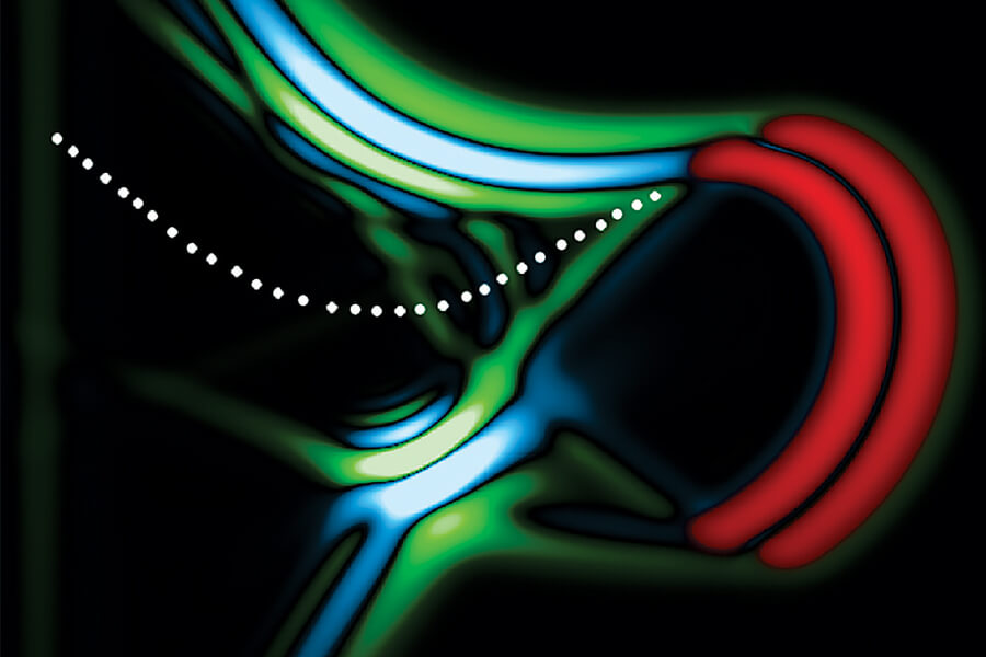 A new device bends visible light inside a crystal to produce “synchrotron” radiation (blue and green) via an accelerating light pulse (red) on a scale a thousand times smaller than massive facilities around the world.