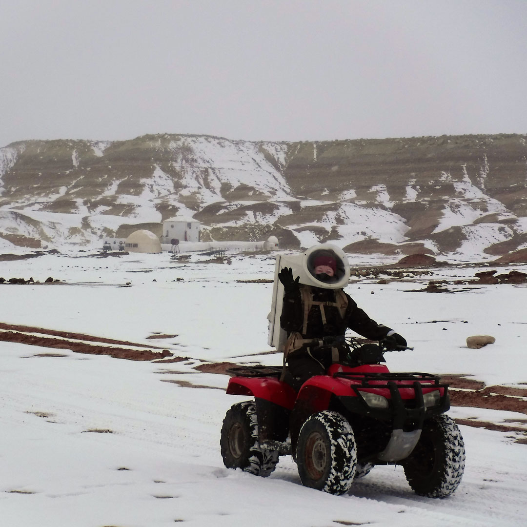 Crew Geologist and Earth, Atmospheric, and Planetary Sciences at Purdue alumna, Ellen Czaplinski, pilots the crew's ATV, which simulate roving vehicles, on the Martian landscape overlooking the MDRS habitat.

