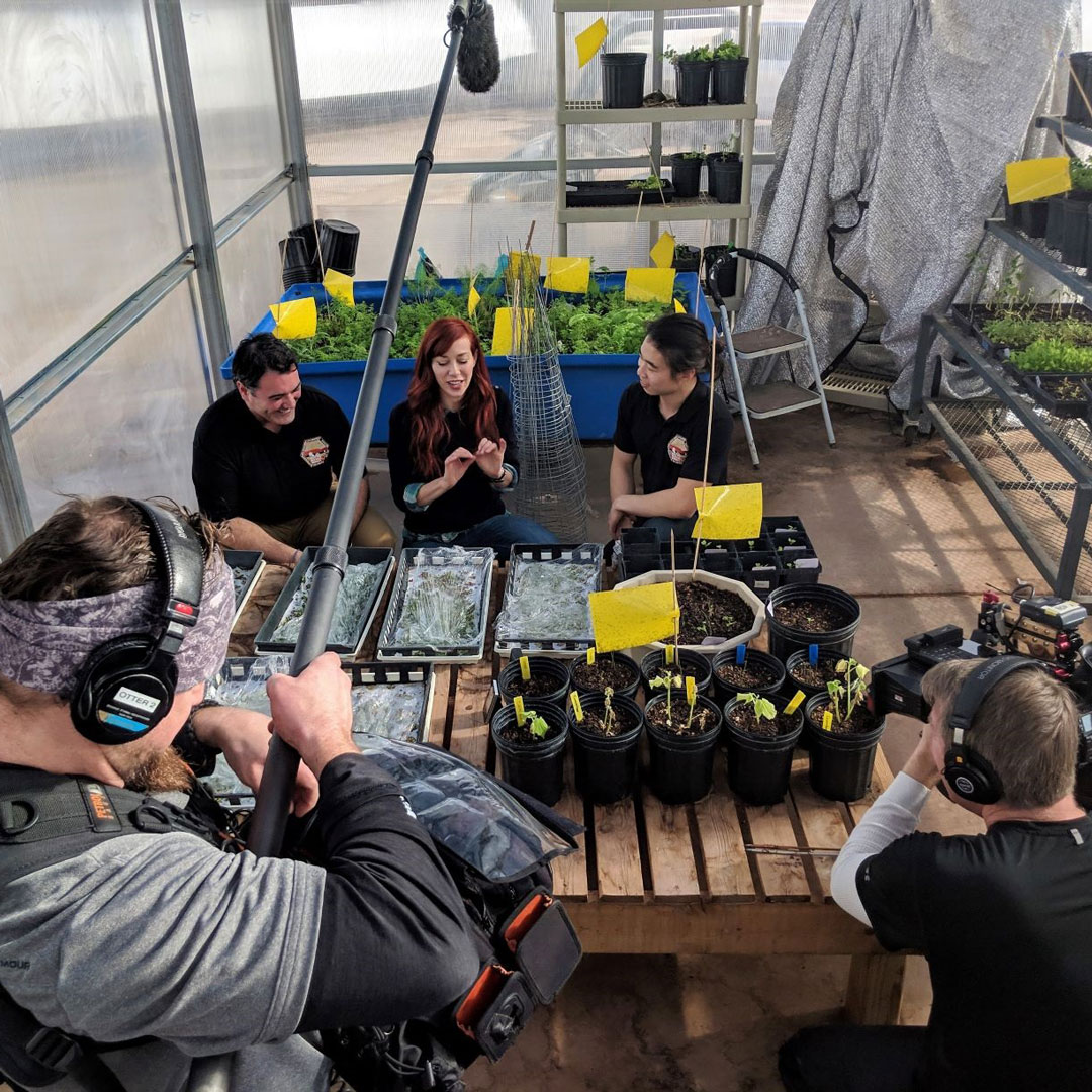 CBS Innovation Nation correspondent, Alie Ward, sits with Health and Safety Officer, Jake Qiu, and Commander, Cesare Guariniello  to discuss Jake's microgreen research in the MDRS Green Habitat.