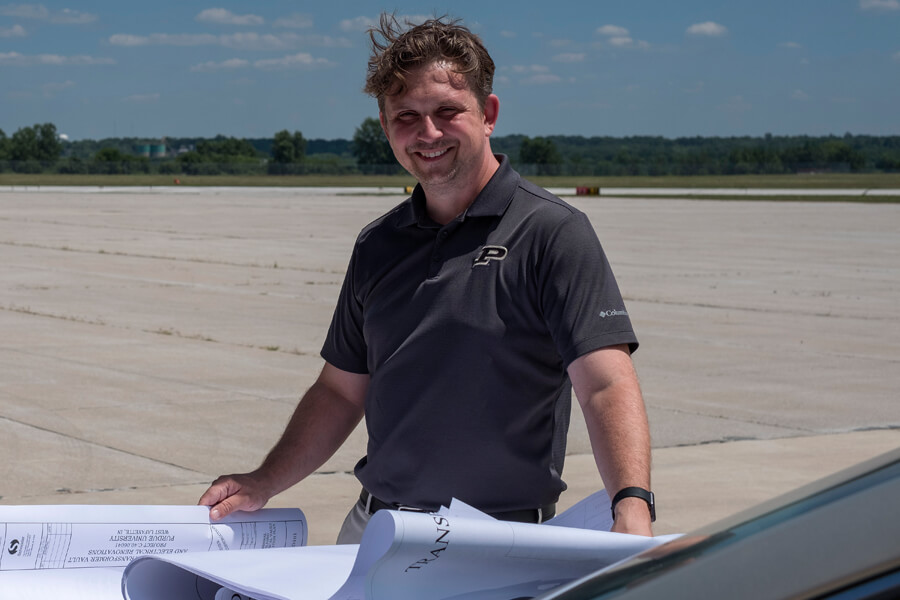 Adam Baxmeyer, Purdue University Airport manager of operations, reviews plans near the airport runway. Purdue is one of the few smaller airports with a traffic control tower. A Purdue-developed technology launched by Bluemac Analytics can help airports improve operations data collection.