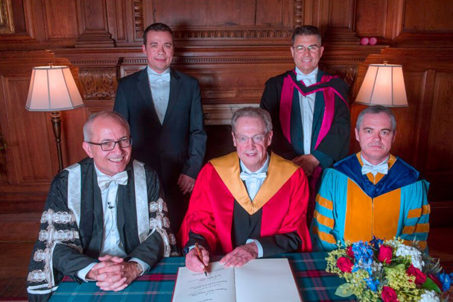 In the group photo, Pipes is seen in the academic attire of the University of Edinburgh, signing the book that contains all the signatures of previous University of Edinburgh honorary degree recipients. The assembled group in the picture include Professor Conchúr M. Ó Brádaigh, (right front), head of the School of Engineering and doctoral student of Dr. Pipes (University of Delaware, circa 1991) and Eduardo Barocio (left rear) current doctoral student of Dr. Pipes (Purdue University). In addition, Acting Vice Chancellor Charlie Jeffery (left front) and another member of the University Court (right rear). All are shown wearing the white bow tie, an Edinburgh tradition for male graduation participants.