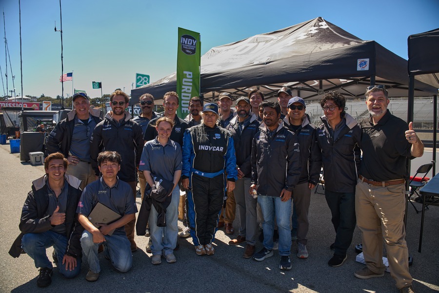Purdue AI Racing team poses with U.S. Assistant Secretary of Transportation Seval Oz at Laguna Seca.
