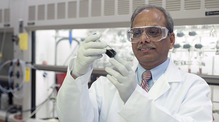 Professor examining a beaker in the lab