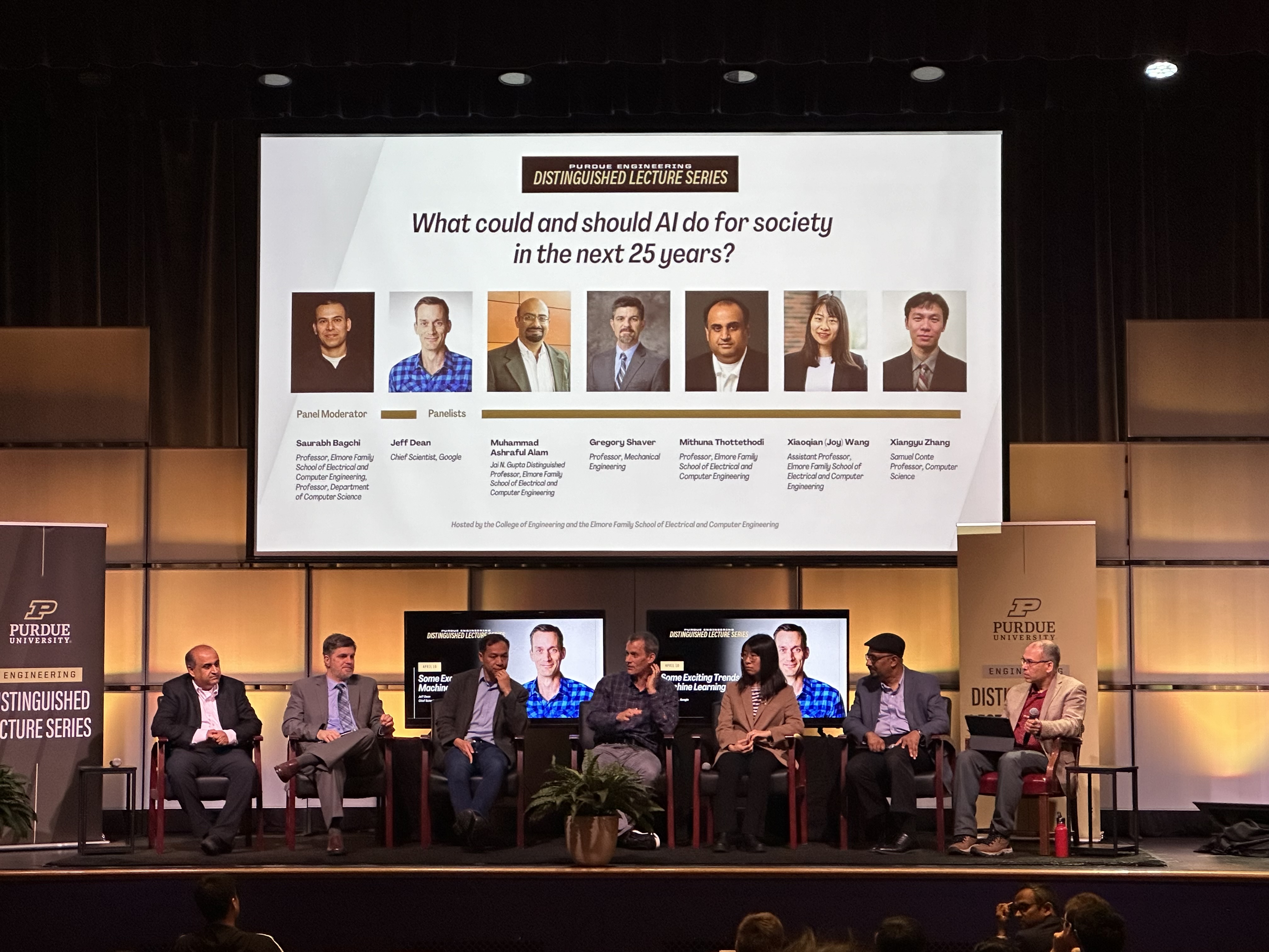 Panel members sitting on stage