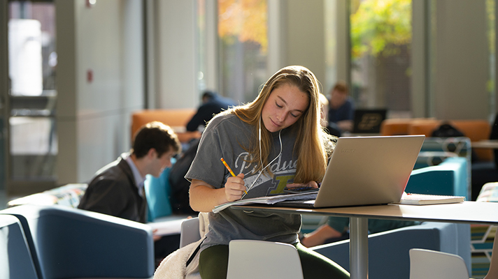 Student writing at a desk.