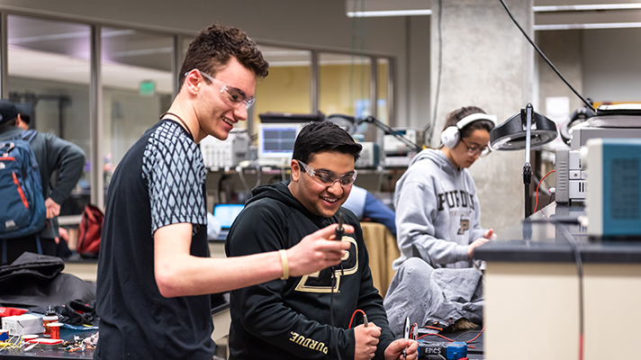 Three students looking at objects.