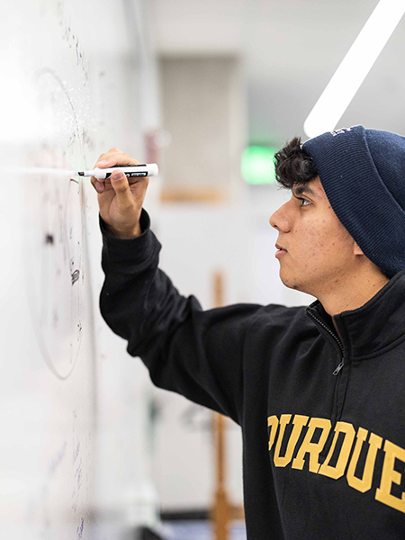 Oliver Juarez writing on a dry erase board