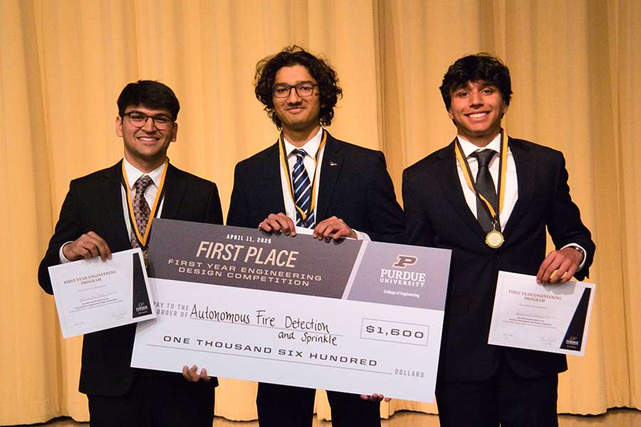 Students smiling, holding a big check