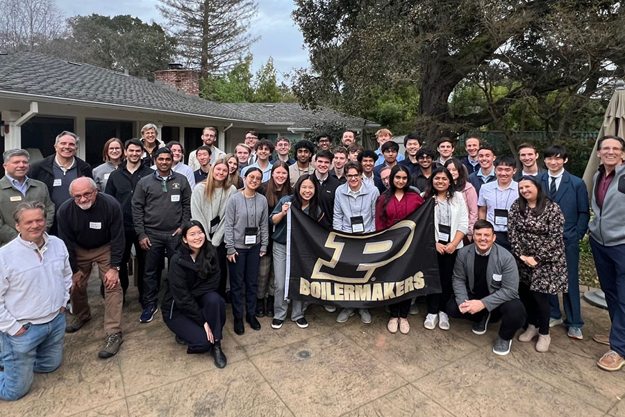 Students, faculty and staff standing outside a house