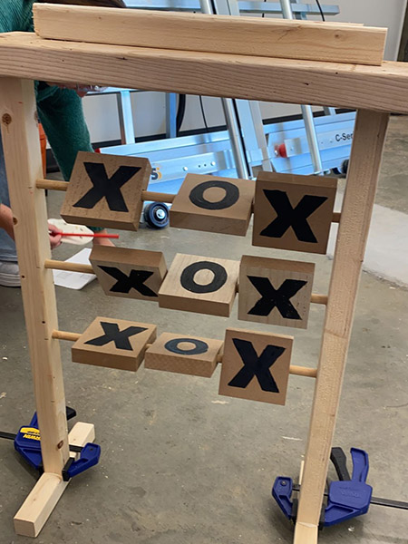 A wooden tic tac toe board