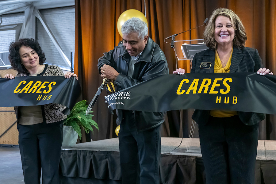 Three people ribbon cutting